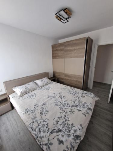 a bedroom with a bed with a floral bedspread at Premium 2 bedroom flat at Millennium 2 in Sveti Vlas
