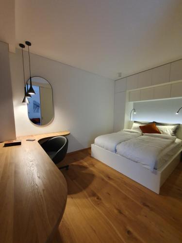 a bedroom with a bed and a table and a mirror at Parko rezidencija apartments - SELF CHECK-IN in Panevėžys