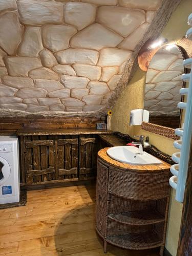 ein Badezimmer mit einem Waschbecken und einer Mikrowelle in der Unterkunft Zelenyj Raj in Pashkivtsi