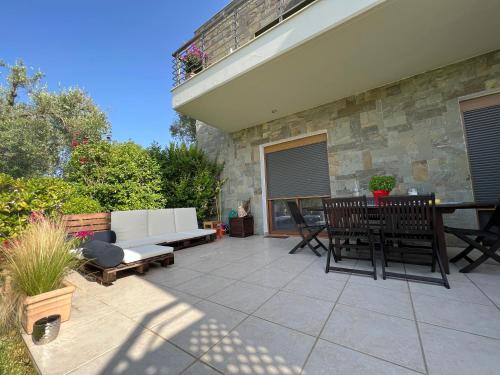 a patio with a couch and a table and chairs at Angelo’s Elegant Summer House in Possidi