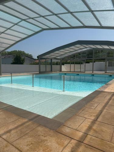 une grande piscine avec un bâtiment en arrière-plan dans l'établissement Chalet avec piscine, climatisation & vue de 2 à 6 personnes - Hasparren - Pays Basque - Chalet Ibaia, à Hasparren