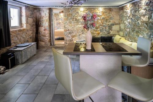 アテネにあるStone Houseのテーブルと白い椅子のあるダイニングルーム