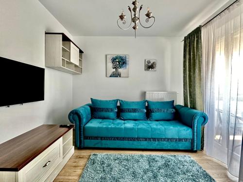 een woonkamer met een blauwe bank en een tv bij 4FriendsCoresiBrasov Blue in Braşov