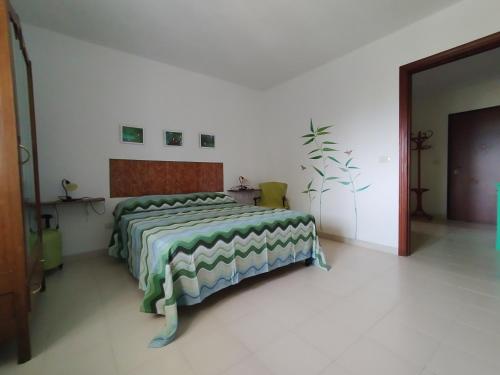 コントゥルシにあるVilla Italiaのベッドルーム1室(緑と白の掛け布団付きのベッド1台付)