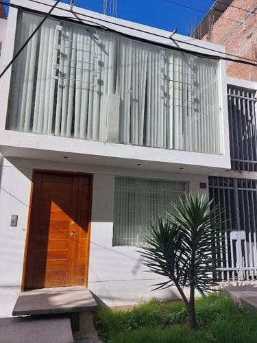 ein Gebäude mit einer Tür und einem Baum davor in der Unterkunft Casa completa, 5 dormitorios y jardín in Ayacucho