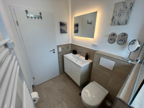 a bathroom with a white toilet and a sink at Fewo Bergperle in Willingen