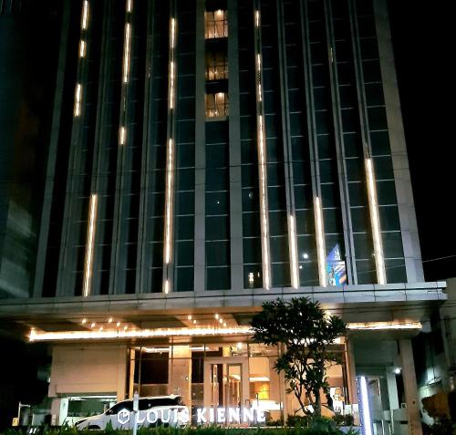 wysoki budynek z znakiem przed nim w obiekcie Warhol Residence at Louise Kienne Simpang Lima Semarang w mieście Semarang