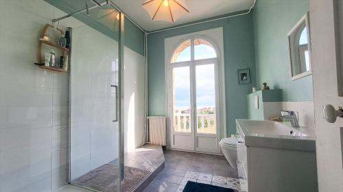 Hautot-sur-Mer的住宿－La déferlante, Magnifique villa vue sur mer à Pourville，带淋浴和卫生间的浴室以及窗户。