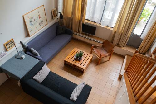 ein Wohnzimmer mit einem blauen Sofa und einem Tisch in der Unterkunft Le Garage in Paris