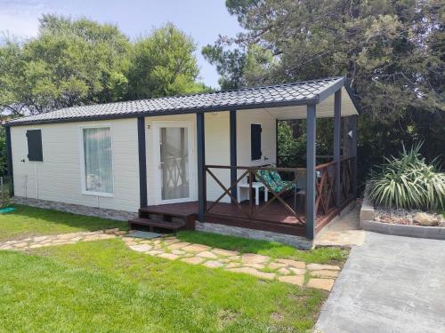 a tiny house with a porch and a deck at Naturalayos I y Naturalayos II - casas para parejas - jacuzzi in Pelayos de la Presa
