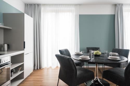 a dining room with a black table and chairs at Velotel Bad Saarow in Bad Saarow