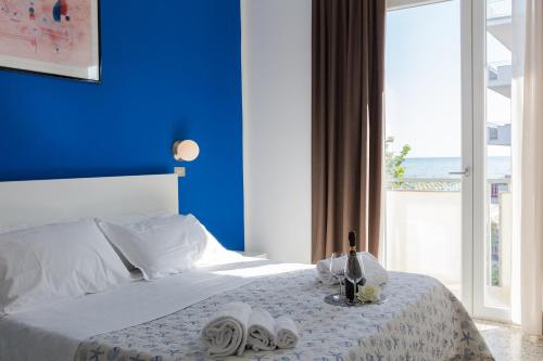 Hotel Sanremo في ريميني: غرفة نوم زرقاء مع سرير بجدار ازرق