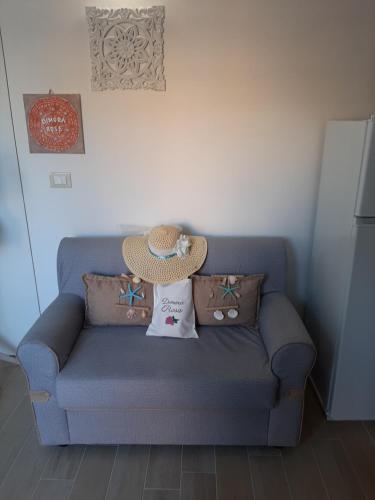 a blue couch with pillows and a hat on it at Dimora Rose in Nardò