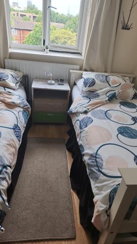 two beds in a room with a window at Seaview in London