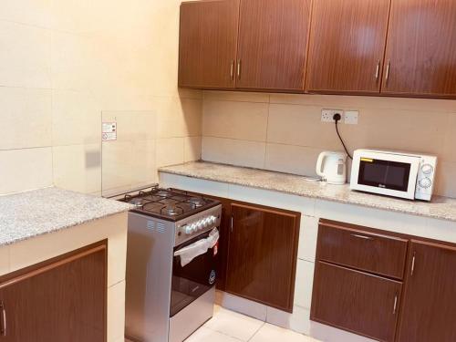 a kitchen with a stove and a microwave at Star Emirates Inn in Salalah