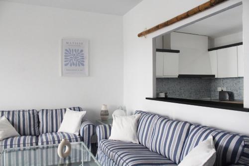 een woonkamer met twee blauwe en witte gestreepte banken bij First line in Puerto Banus (Primera linea) in Marbella