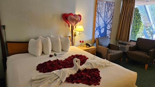 a hotel room with a bed with a swan made out of roses at The Cedars Inn Hotel & Convention Centre in Gibsons