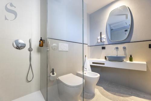 a bathroom with a toilet and a sink and a mirror at Sud Hotel Pulsano in Pulsano