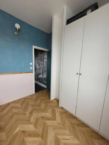 an empty room with a wooden floor and white doors at Logement de Ville 4 chambres proche de Lille in Tourcoing