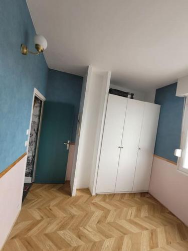 a room with white cabinets and a wooden floor at Logement de Ville 4 chambres proche de Lille in Tourcoing