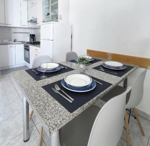 a kitchen with a table with plates and utensils at Apartment Lori in Crikvenica
