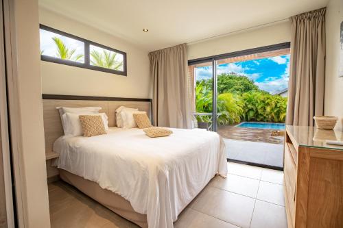 une chambre avec un lit et une grande fenêtre dans l'établissement Villa Rishna By Abaneo, Saint-François, à Saint-François