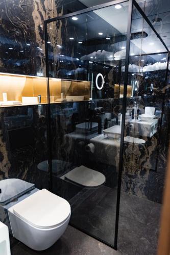 a bathroom with a toilet and sinks in a room at Hotel Vibre in Cluj-Napoca