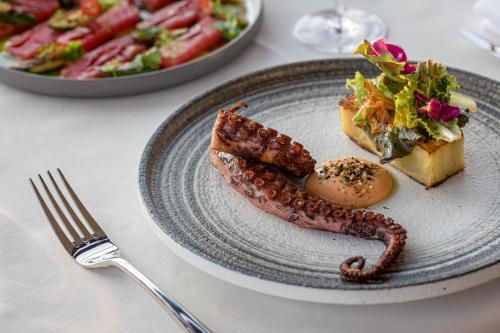 a plate of food with sausage and a salad at Hotel Vibre in Cluj-Napoca