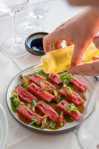 a plate of food on a table with a person pouring a sauce at Hotel Vibre in Cluj-Napoca