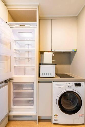 a kitchen with a washing machine and a refrigerator at Elbon The beach Haeundae in Busan