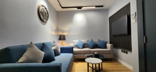 a living room with a blue couch and a tv at Qasr Al Sahab in Khamis Mushayt