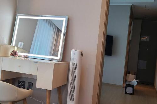 a room with a desk with a mirror and a radiator at Elbon The beach Haeundae in Busan