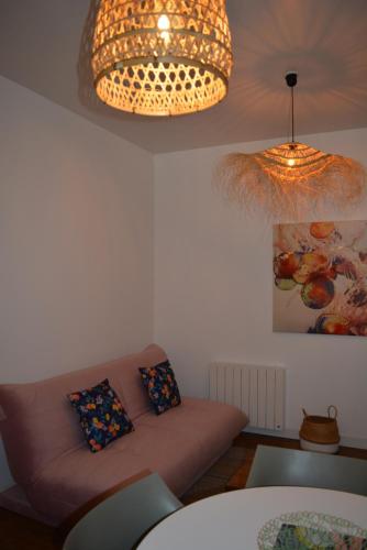 a living room with a couch and two pillows at Appartement, Royan. Proche plage. in Royan