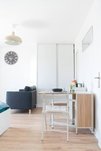un salon avec une table et un canapé dans l'établissement Le Citadin-T1-28m2-Pte Paris M7, au Kremlin-Bicêtre