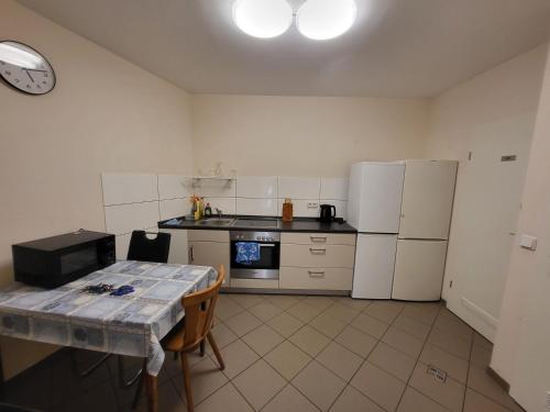a kitchen with white appliances and a table in it at Jelinski Beherbergungsstätten Ostingersleben in Ostingersleben
