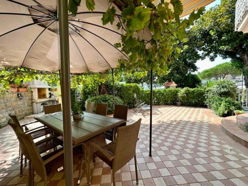 Villa Milada في بوروتوروج: طاولة وكراسي مع مظلة على الفناء