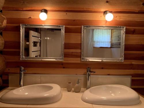 a bathroom with two sinks and two mirrors at Hébergement d'exception à Zonza in Zonza