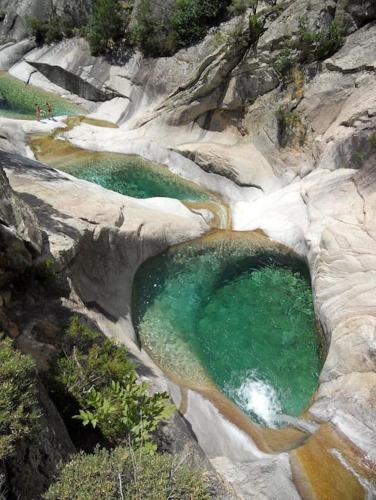 an aerial view of two pools of water on a rocky mountain at Hébergement d'exception à Zonza in Zonza