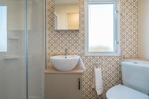 W łazience znajduje się umywalka, lustro i toaleta. w obiekcie 3 Bed Static Caravan-Seton Sands w mieście Longniddry