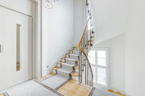 - un escalier en colimaçon dans une chambre blanche dotée d'une fenêtre dans l'établissement Bel Appartement avec balcon proche Roland Garos et Parc des Princes, à Boulogne-Billancourt