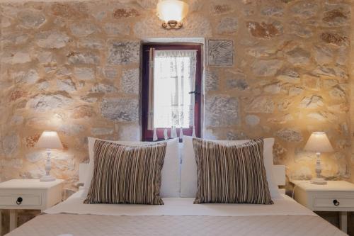 a bedroom with a bed with two pillows and a window at Ampelos Tower in Kokkala