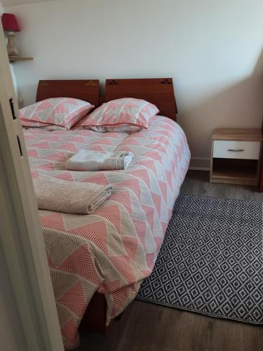 - une chambre avec un lit, 2 oreillers et un tapis dans l'établissement Nid douillet proche de la mer et de la gare, à Houlgate