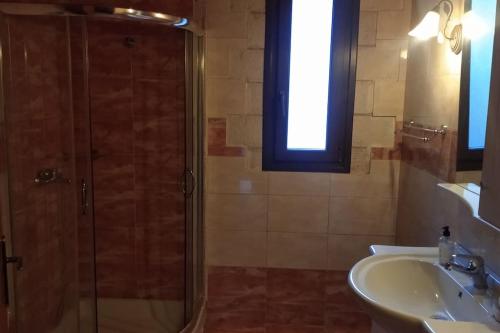 W łazience znajduje się szklana kabina prysznicowa i umywalka. w obiekcie Βίλλα Τρία Ποτάμια καταρράχτες ΝΈΔΑ 