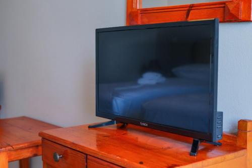 a flat screen tv sitting on top of a wooden table at Hotel Korfos - Ξενοδοχείο Κόρφος Renovated in Korfos