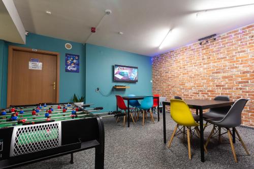 a room with a foos ball table and chairs at Moon Hostel Gdańsk in Gdańsk