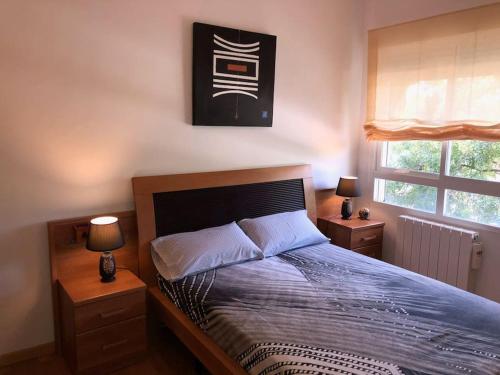 1 dormitorio con 1 cama grande y 2 mesitas de noche en VUT EL PARQUE PISO 3DORMITORIOS Y 2 BAÑOS CON PISCINA EN VERANO., en Ciudad Real
