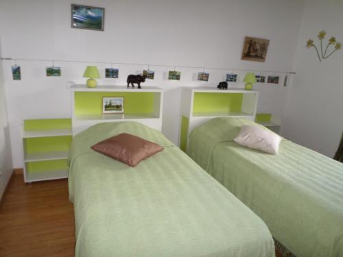 two beds in a room with green and white at L'Esquerade in Castillon-de-Larboust