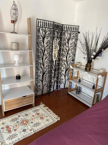 ein Schlafzimmer mit einem schwarz-weißen Vorhang und einem Regal in der Unterkunft Studio Bas de villa avec grande terrasse in Piedigriggio