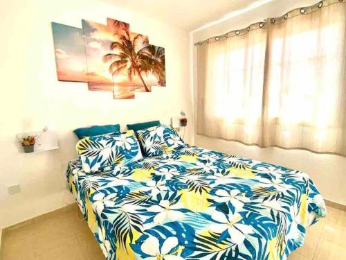 een slaapkamer met een bed met een blauw en wit dekbed bij Confortable y céntrico in Los Cristianos