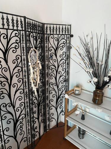 un portail noir et blanc dans une pièce avec un vase dans l'établissement Studio Bas de villa avec grande terrasse, à Piedigriggio